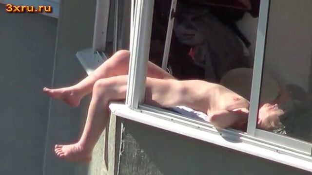 Naked chick sunbathing on the balcony