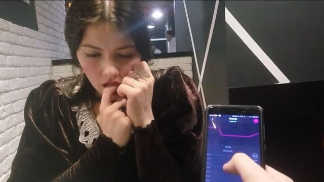 A girl tries a vibrator on herself in a restaurant
